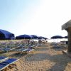 Spiaggia con ombrelloni blu e lettini.