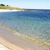 Spiaggia sabbiosa e mare cristallino.