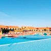 Piscina all'aperto con sdraio e ombrelloni.