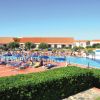 Piscina affollata con lettini e ombrelloni.