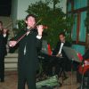 Gruppo musicale con violini e chitarra suona sul palco all'aperto.