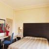 Una camera d'albergo con letto matrimoniale, scrivania, televisore e sedia blu.