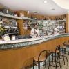 Un bar con bancone curvo, barista in divisa e vari scaffali di bottiglie.