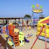 Area giochi colorata per bambini sulla spiaggia, con scivoli e gonfiabili.