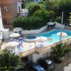 Piscina con lettini e ombrelloni sopra un parcheggio.