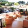 Terrazza con sedie in vimini e ombrellone.
