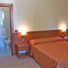 Camera d'albergo con letto, bagno e lampade a parete.