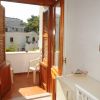 Balcone con sedie e porta in legno aperta.