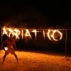 Uomo con torcia infuocata davanti a scritta di fuoco 