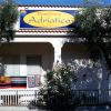 Facciata di un residence con insegna gialla e pareti bianche.