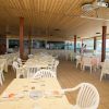 Ristorante con tavoli apparecchiati e sedie bianche.