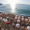 Spiaggia con ombrelloni bianchi e arancioni al tramonto.
