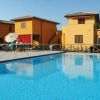 Piscina ampia con edifici color ocra sullo sfondo.