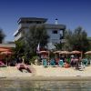 Spiaggia con ombrelloni, sedie a sdraio e persone sul bagnasciuga.