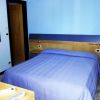 Camera con letto blu, scrivania e parete turchese.