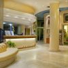 Lobby dell'hotel con reception moderna e piante.