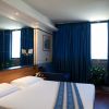 Camera d'albergo con letto matrimoniale e tende blu.