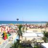 Spiaggia con ombrelloni colorati e giochi per bambini.