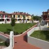Complesso residenziale con edifici colorati e giardino centrale.