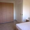 Una stanza con armadio a sei ante, letto accanto a un comodino, pavimento in piastrelle.