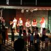 Intrattenimento sul palco con bambini che guardano.