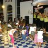 Bambini danzano di fronte a un palco con animatori.