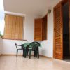 Balcone con tavolo e sedie verdi.