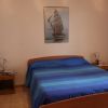 Camera da letto con letto matrimoniale e quadro nautico sul muro.