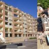 Edificio moderno con balconi e statua di cavallo bianco in primo piano.