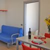 Soggiorno con divano blu, tavolo apparecchiato, fiori in vaso e sedia rossa.