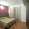 Stanza d'albergo moderna con letto matrimoniale, pareti bicolore e tende chiare.