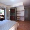 Camera con letto matrimoniale, scrivania, TV a muro e balcone. Vista su edifici rossi.