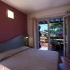Letto matrimoniale vicino a porte scorrevoli, terrazza con tavolo. Parete viola.