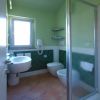 Un bagno verde con doccia, lavabo e bidet, dotato di finestra e piastrelle verdi.