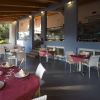 Ristorante elegante con tavoli apparecchiati con tovaglie rosse e sedie bianche.
