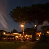 Ristorante all'aperto illuminato di sera, atmosfera calda.