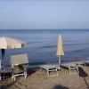 Due lettini con ombrelloni su una spiaggia sabbiosa di fronte al mare calmo.
