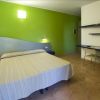 Camera con letto matrimoniale, pareti verde e bianca, con scrivania e sedie.