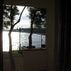 Vista mare oltre un balcone con alberi.
