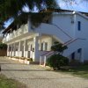 Edificio a due piani bianco con balconi.