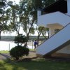 Edificio bianco con scale esterne, alberi vicino al mare.