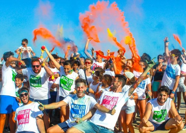 Persone felici con magliette colorate lanciano polveri.