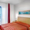 Camera con letto rosso e vista sul mare.