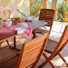 Tavolo apparecchiato su una terrazza con sedie in legno.