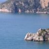 Costa rocciosa sul mare blu con scogliere.