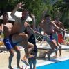 Un gruppo di persone salta in piscina.