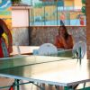 Due persone giocano a ping pong all'aperto.