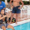 Un uomo prepara l'attrezzatura subacquea a bordo piscina.