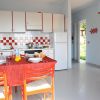 Cucina con tavola apparecchiata e mobili bianchi e rossi.