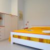 Camera da letto con letto matrimoniale e mobili bianchi.